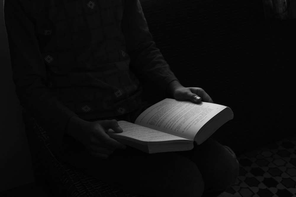 grayscale photo of person reading book