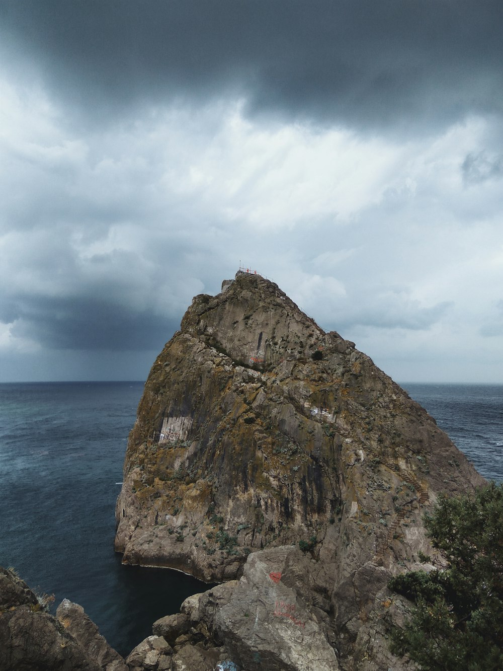 brown rock formation on sea under white clouds during daytime