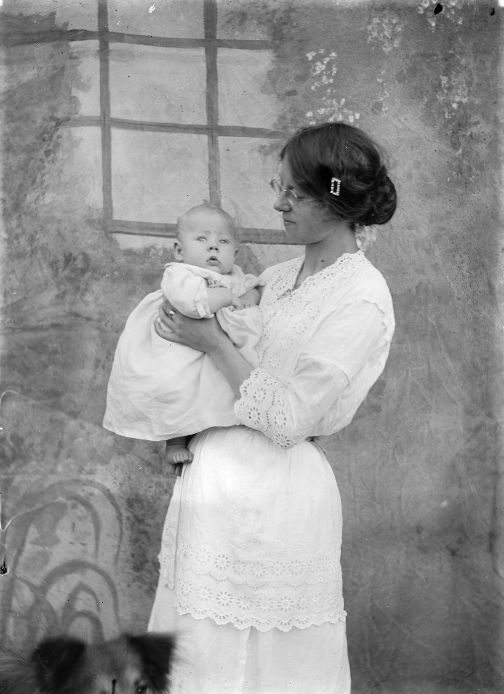grayscale photo of woman in white dress carrying baby