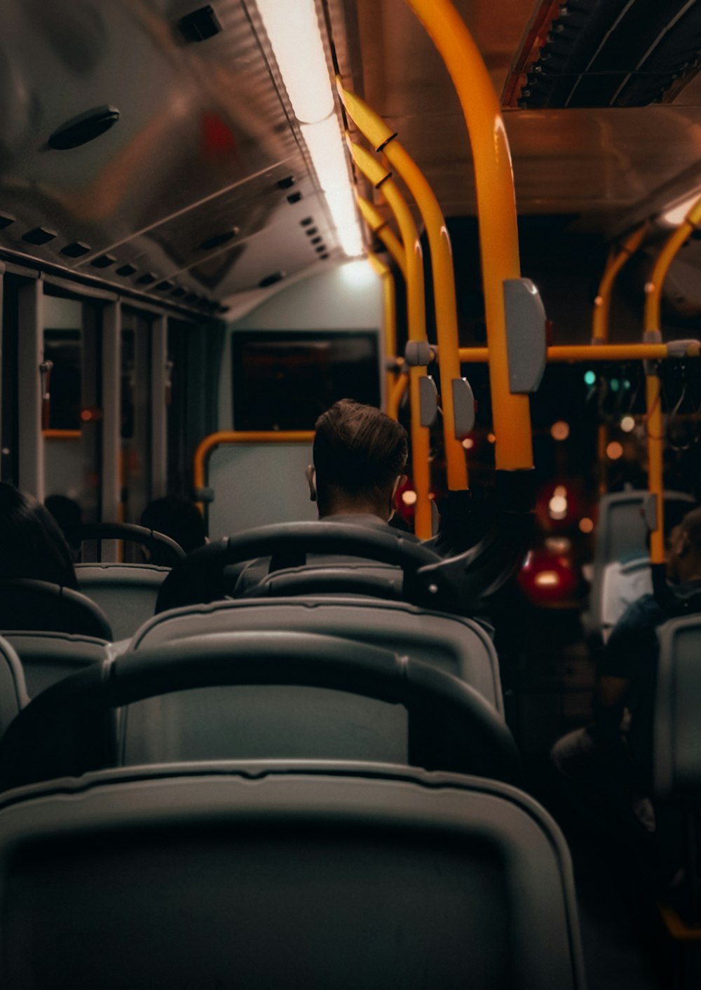 uomo in camicia nera che si siede sul sedile dell'autobus