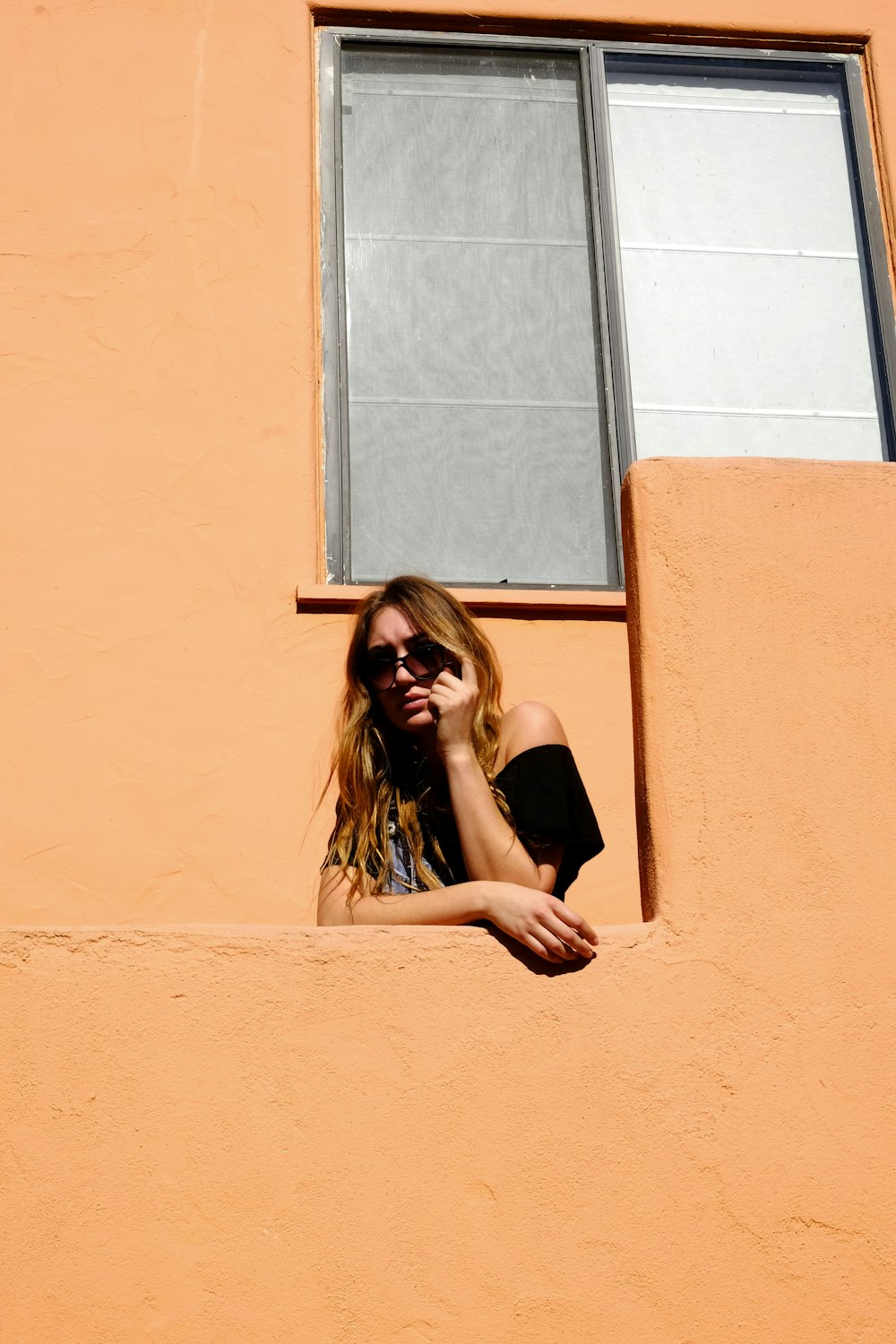 woman in black tank top standing beside window