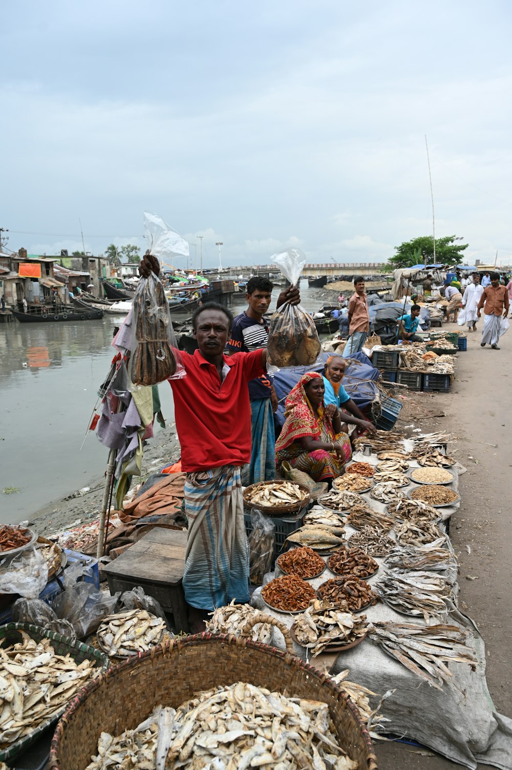 personnes assises sur des roches grises près d’un plan d’eau pendant la journée