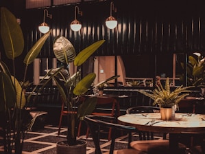 Cozy modern restaurant interior with pink and green leaf accents and warm lighting.