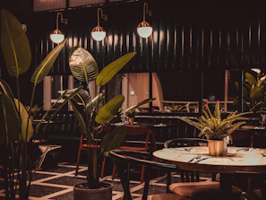 Evening ambiance of the restaurant with soft golden lights and lush green plants.