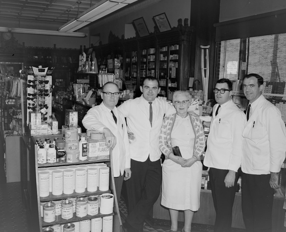 group of men in white uniform standing in front of store