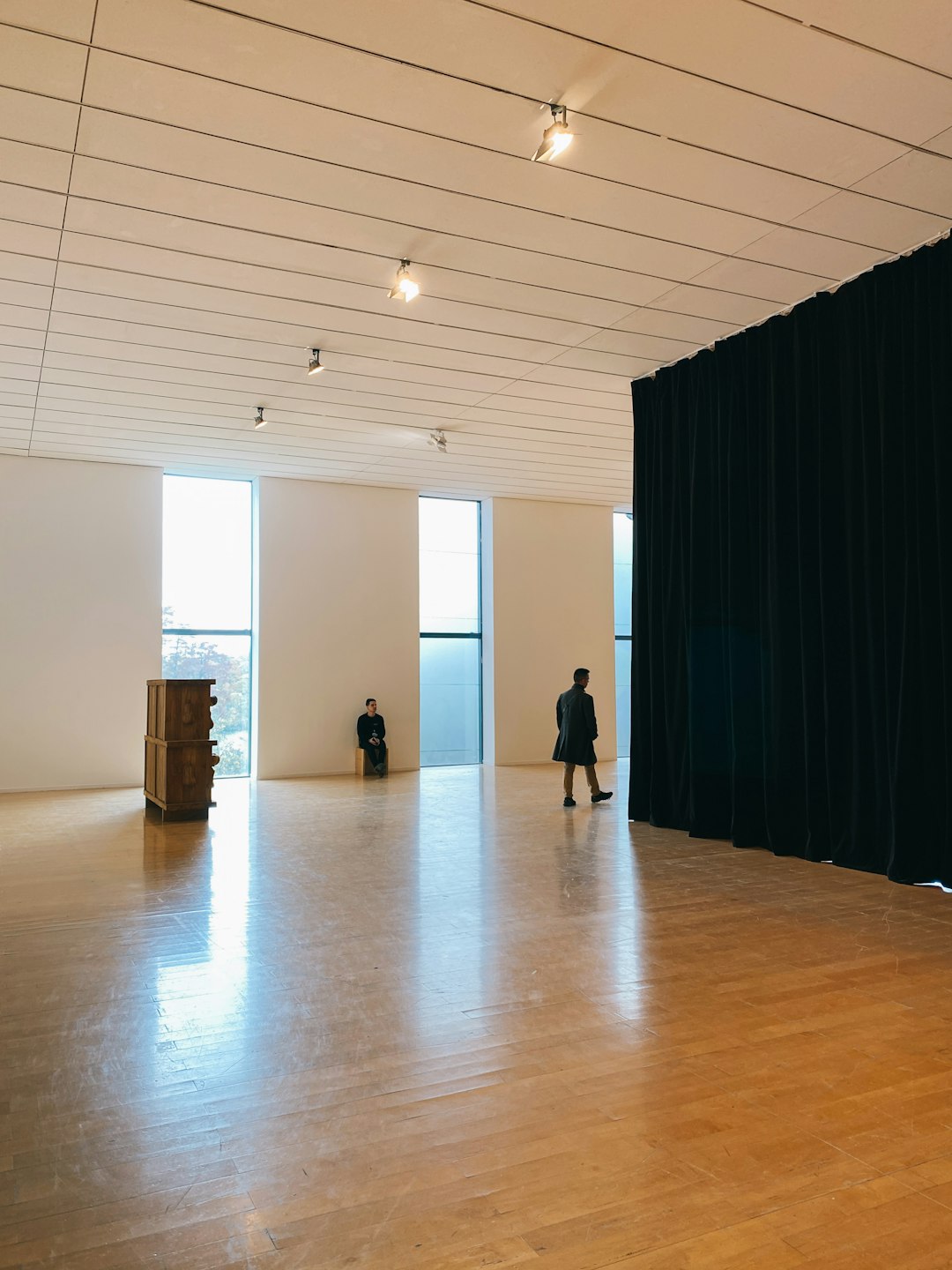 people walking on brown wooden floor