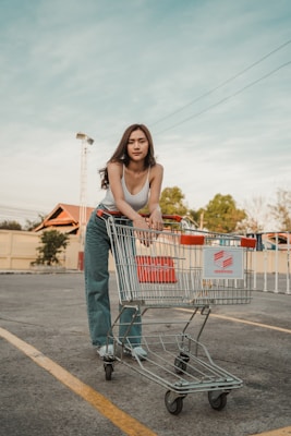 woman in blue denim jacket holding shopping cart