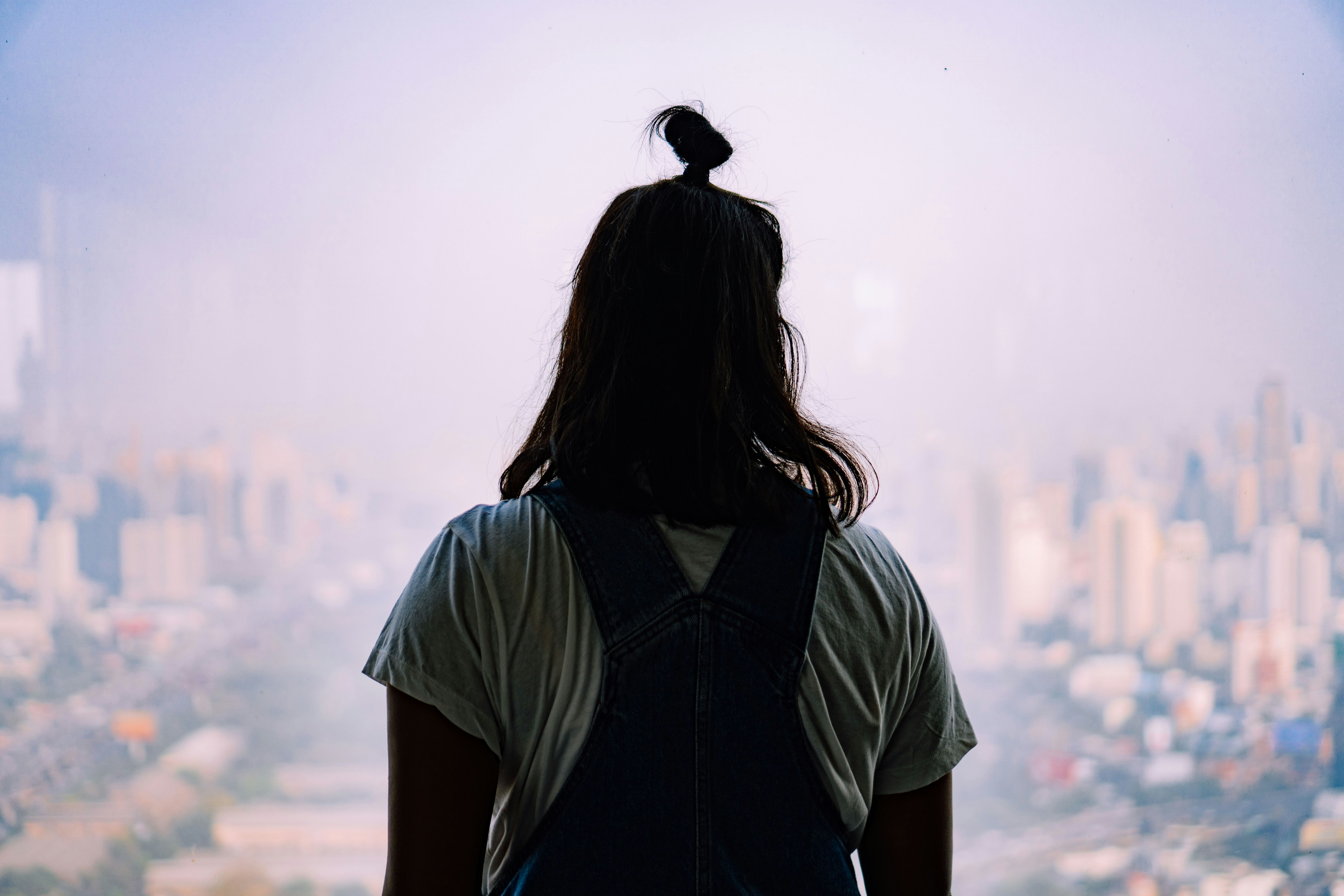 woman in blue shirt standing on top of mountain during daytime