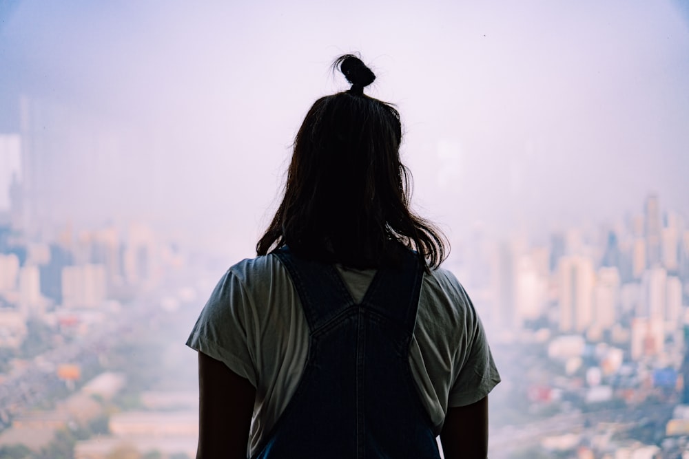 woman in blue shirt standing on top of mountain during daytime