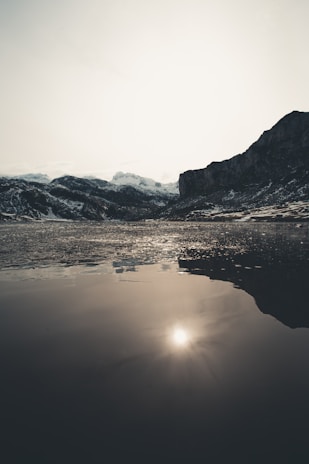 A serene mountain lake reflecting the soft glow of dawn, inviting calm and focus.