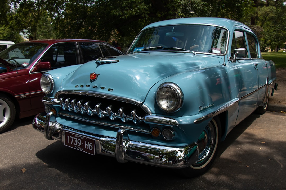 blue classic car parked on the side of the road