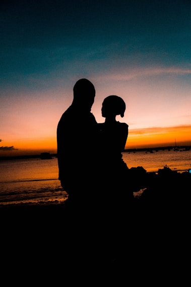 A vibrant sunset over Sharm El Sheikh beach, with a silhouette of a couple embracing.