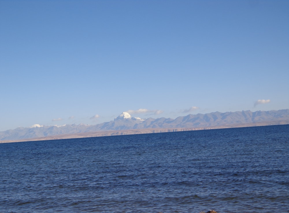 blue sea near mountain under blue sky during daytime