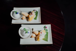 A selection of special desserts featuring soft pastel tones and delicate green leaf garnishes on a simple white plate.