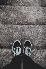 A pair of modern sneakers resting on a graffiti-covered urban stairwell.