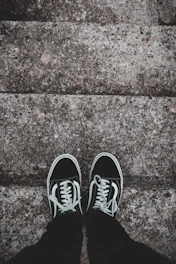 Minimalist sneakers resting on a concrete stairwell.