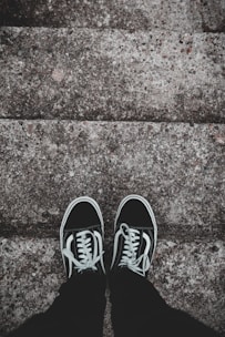 A pair of modern sneakers resting on a graffiti-covered urban stairwell.