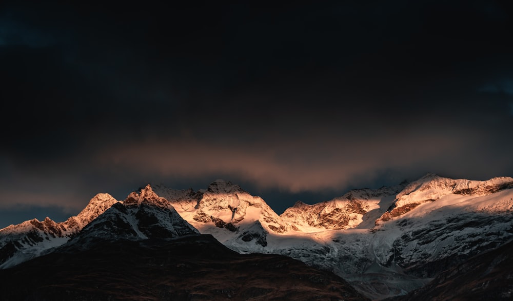 montaña cubierta de nieve bajo el cielo nublado durante el día