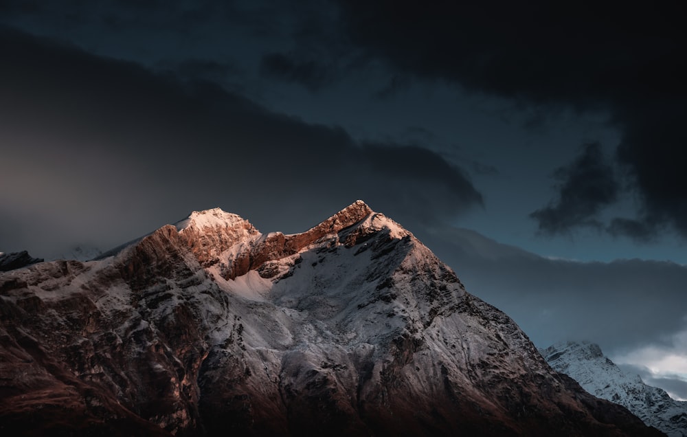 montagne enneigée sous ciel bleu pendant la journée