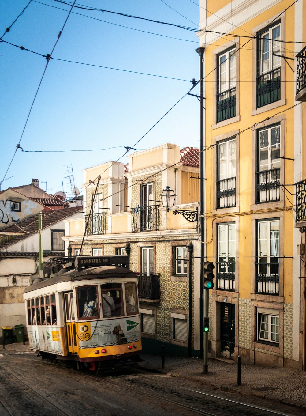 Tram blanc et marron devant un bâtiment en béton beige pendant la journée