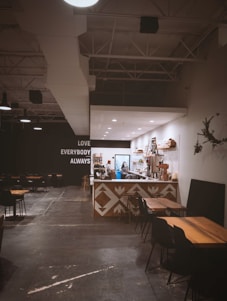 Warm interior of 24 Dreams Cafe with wooden tables, soft lighting, and a barista preparing coffee.