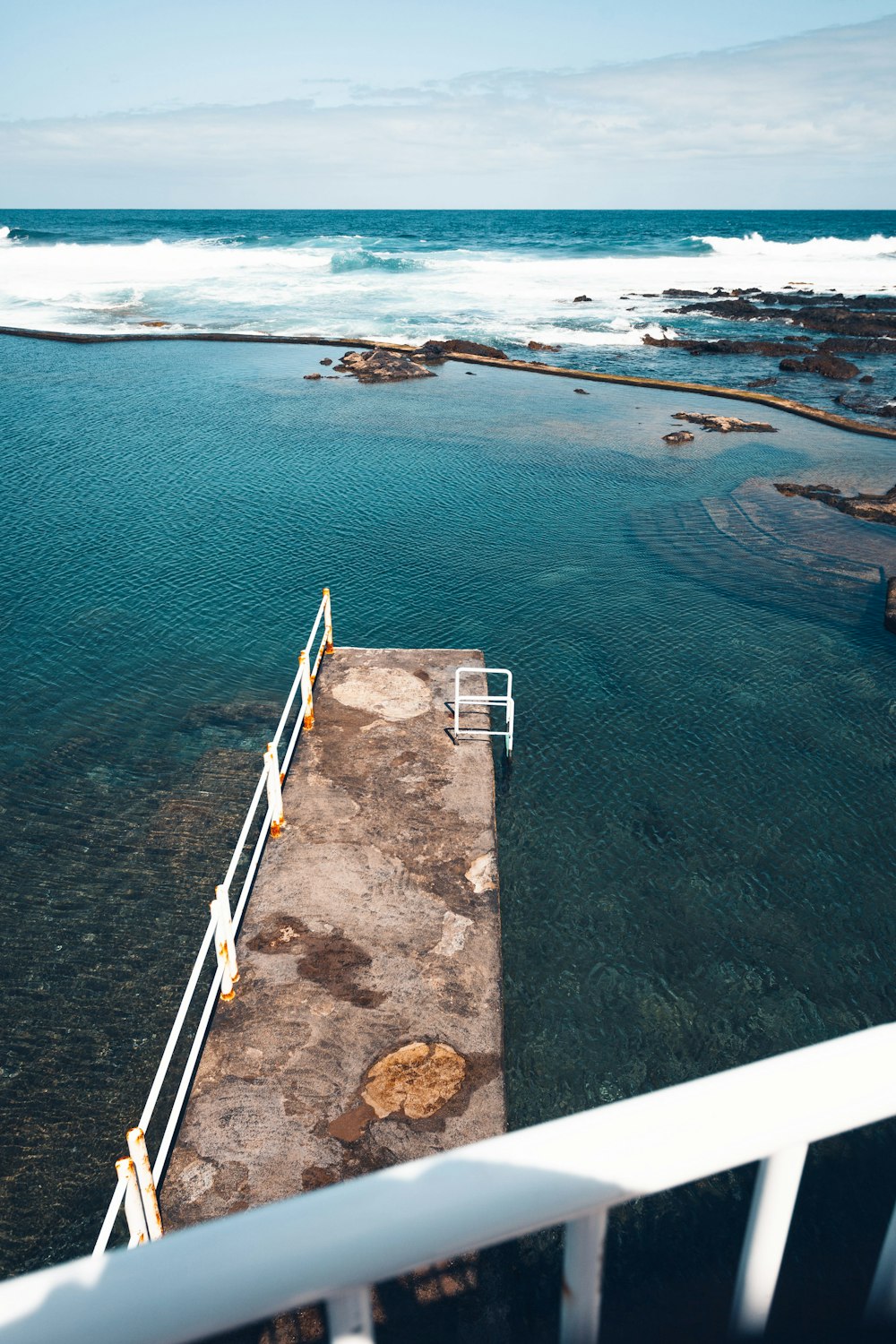 white and brown wooden dock on blue sea during daytime