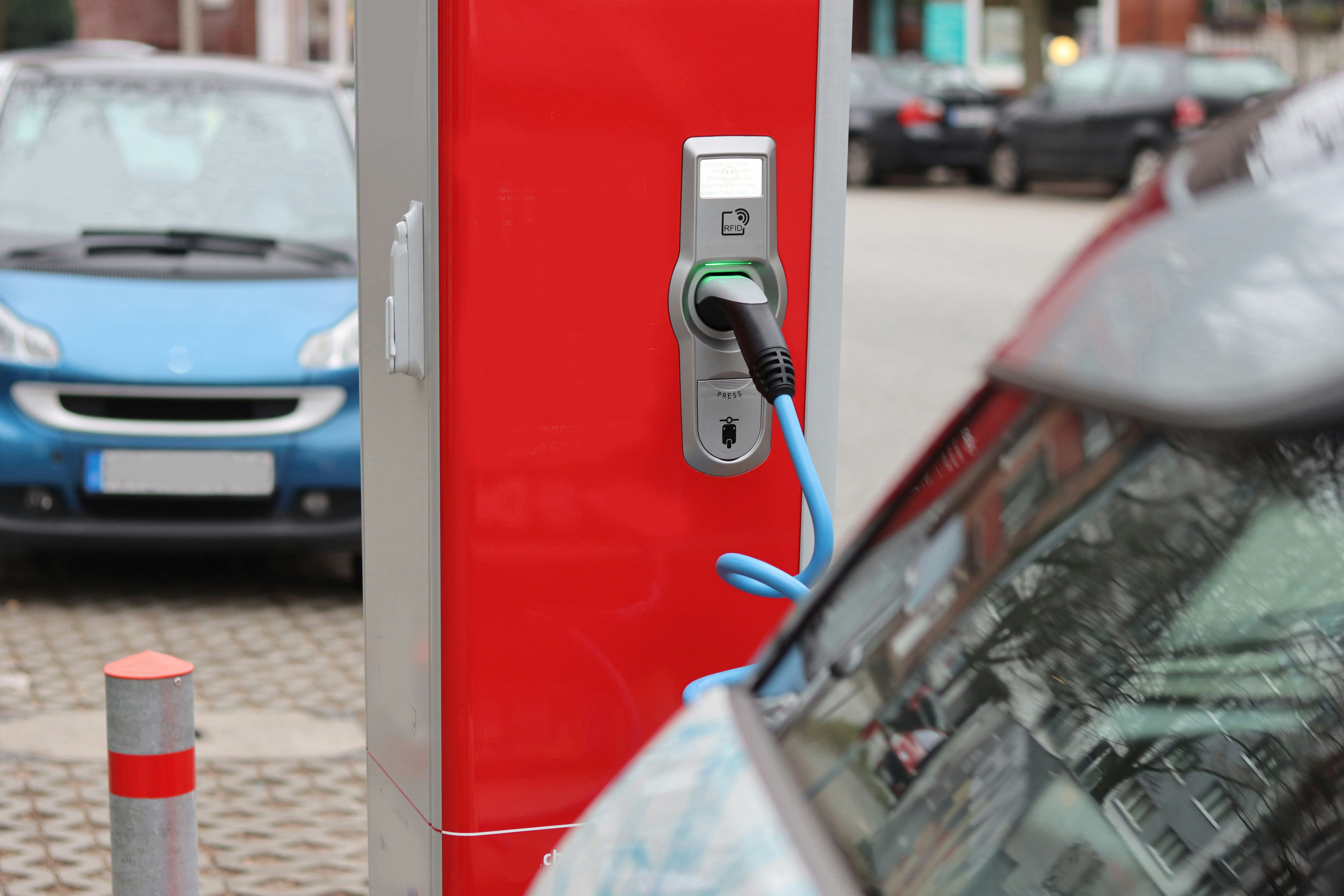 red and black car door, base station, station, charge base, charge station, charging station, recharging unit, charging point, electric vehicle charging station, electric vehicle, electric drive vehicle, electrically powered vehicle, vehicle, cars, red, e-car, electric car, electrically powered car, plug-in car, cars, street
