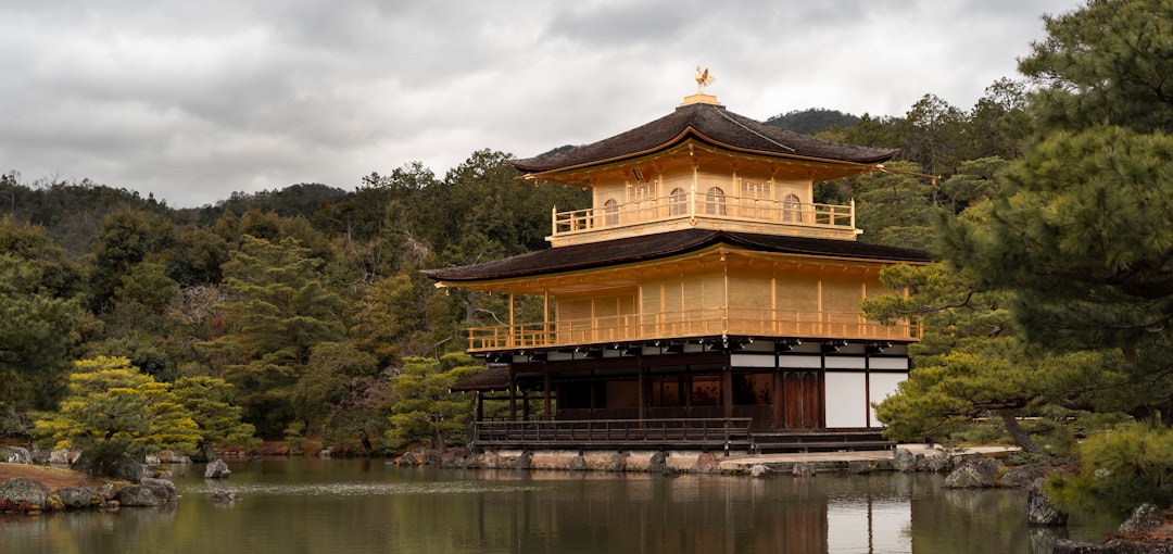 brown and white wooden house near body of water during daytime