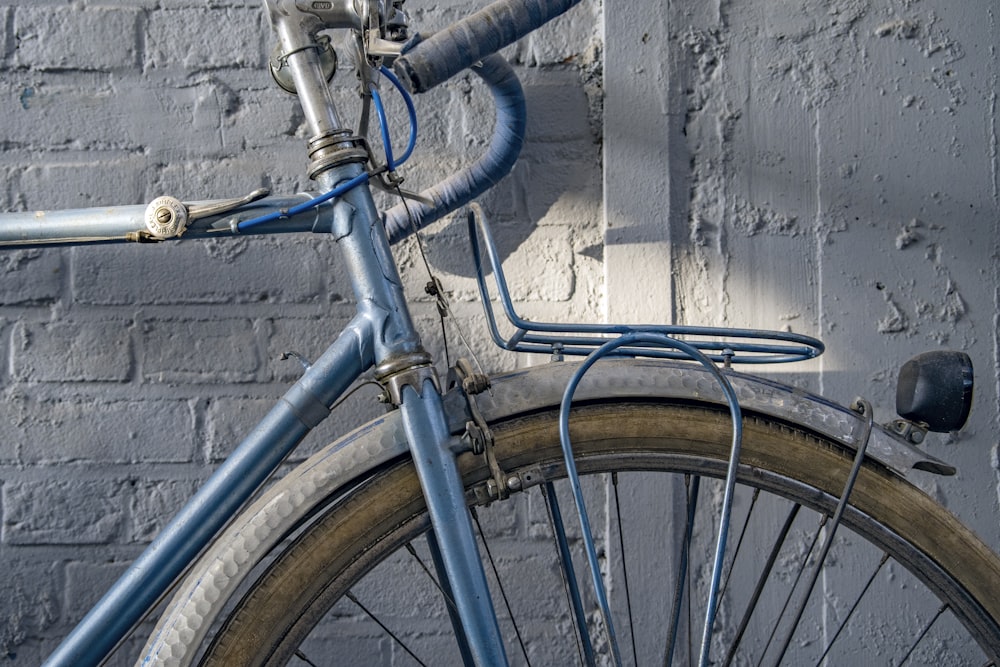 blue and silver bicycle leaning on blue metal fence