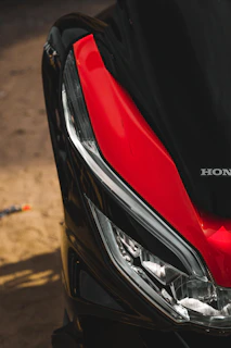 Side view of a motorbike featuring a modern silver and red custom headlamp