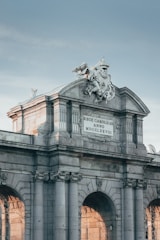 white concrete building with statue of man riding horse