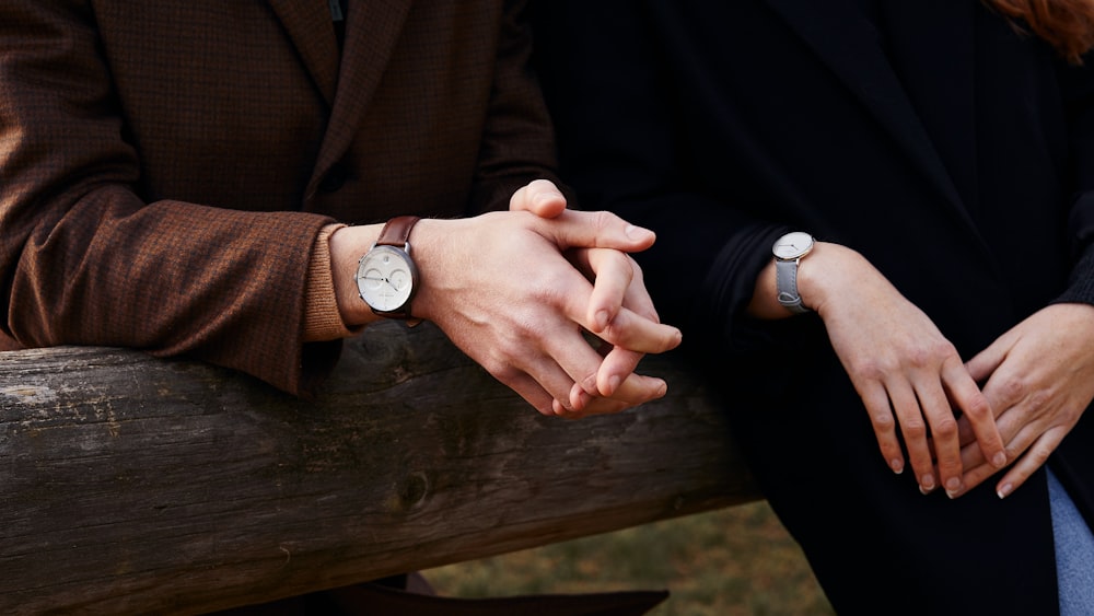 person wearing brown coat and silver round analog watch