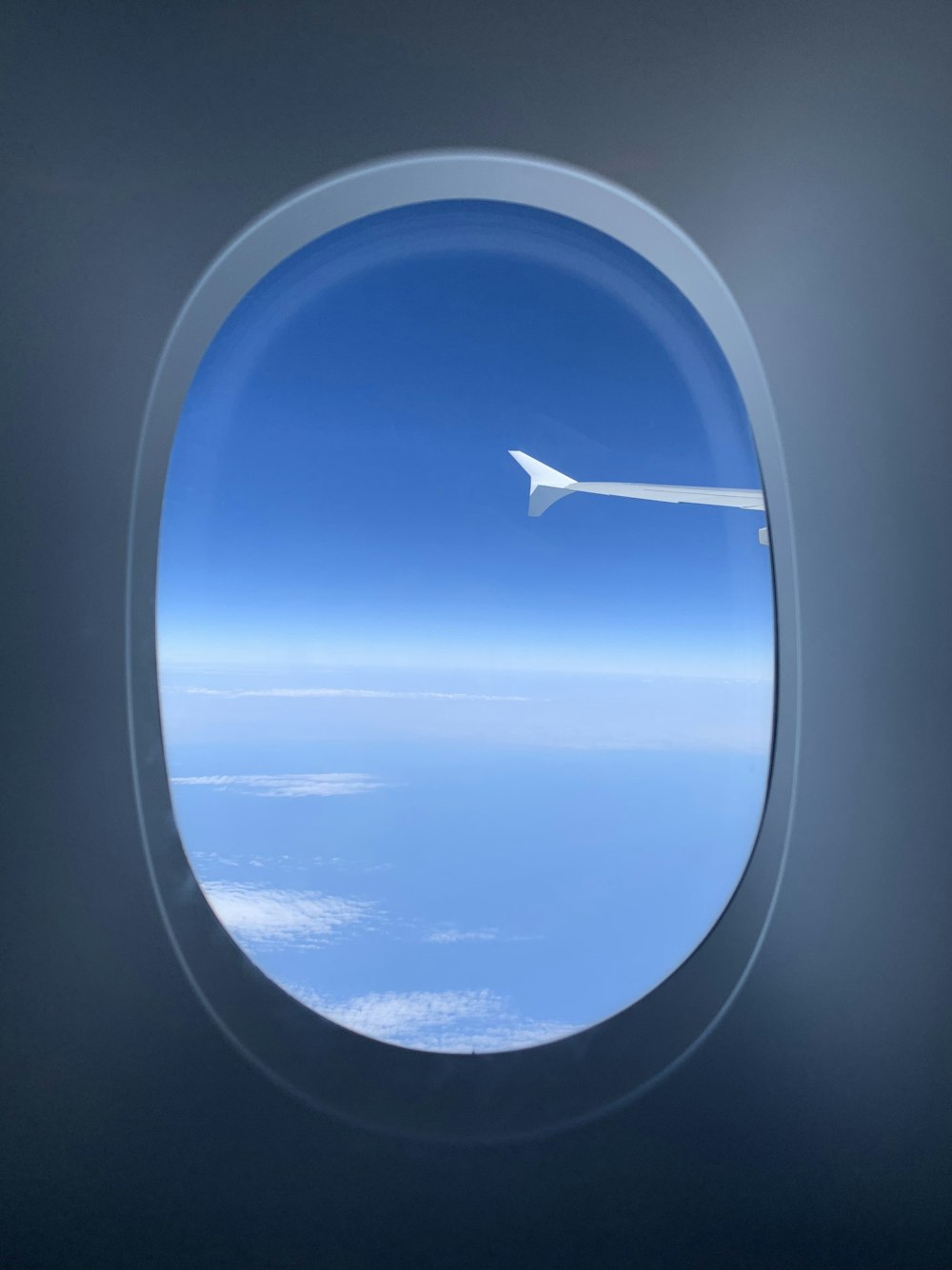 airplane window view of clouds and blue sky during daytime