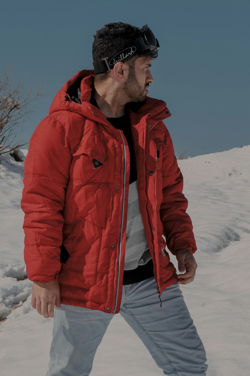 man in red zip up jacket standing on snow covered ground during daytime