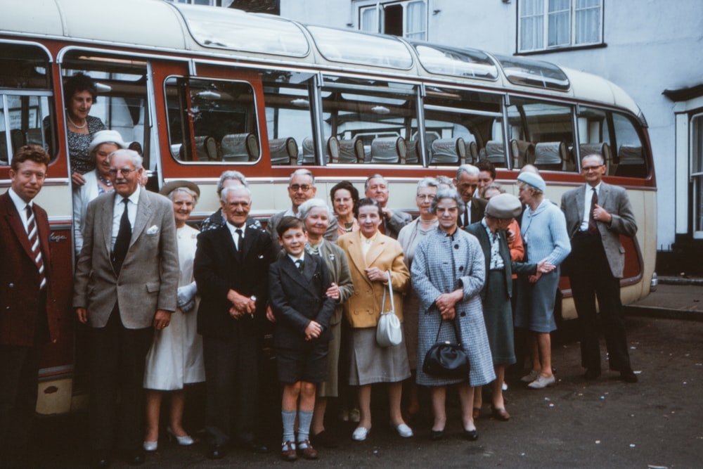 group of people standing beside white bus