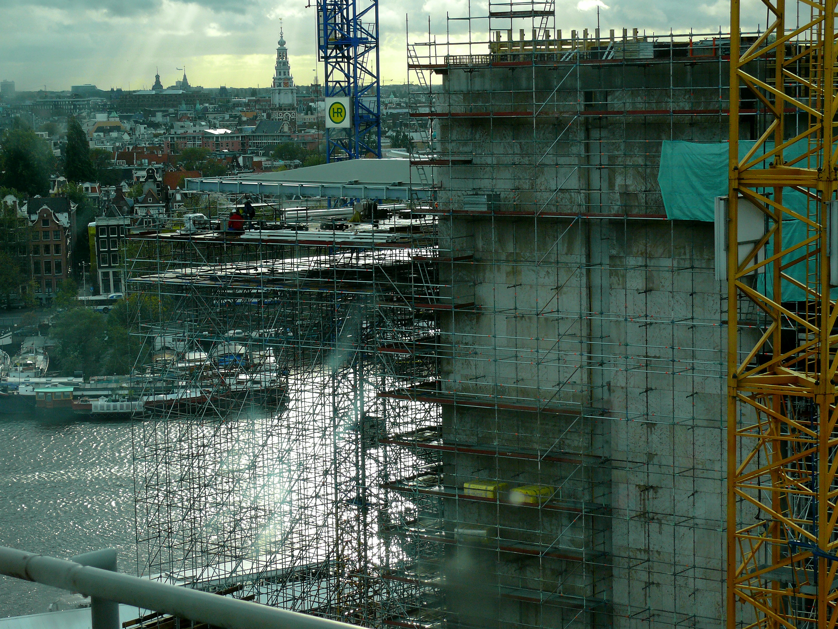 Active property construction site with concrete structure rising, cranes and scaffolding, professional development in progress