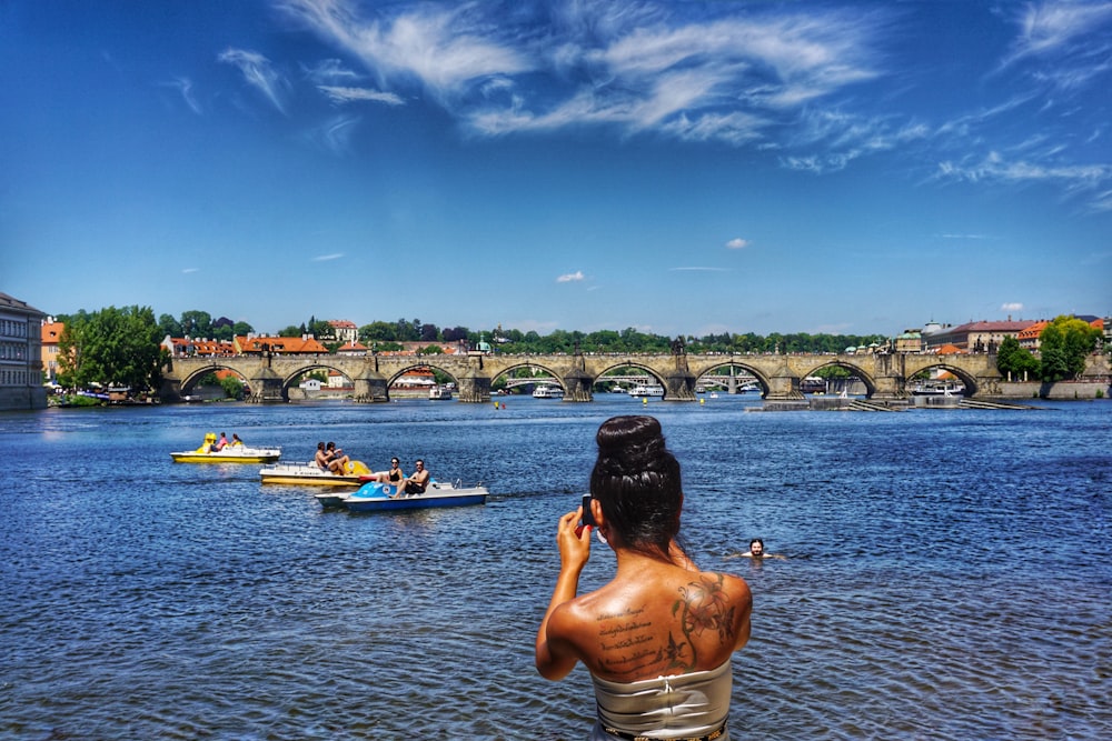 topless man sitting on boat on water during daytime