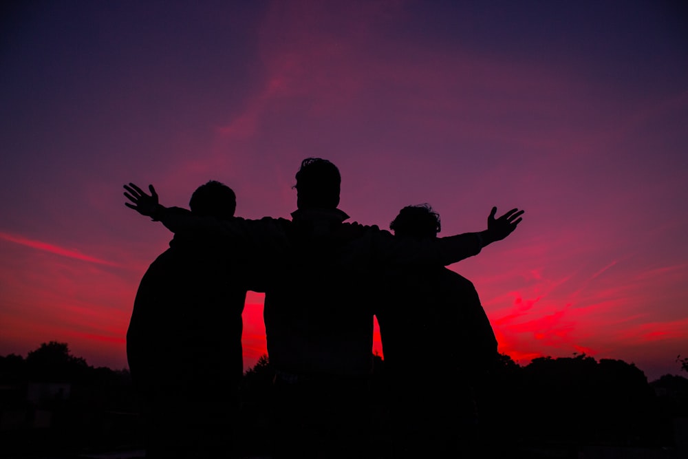 silhouette of man and woman standing during sunset