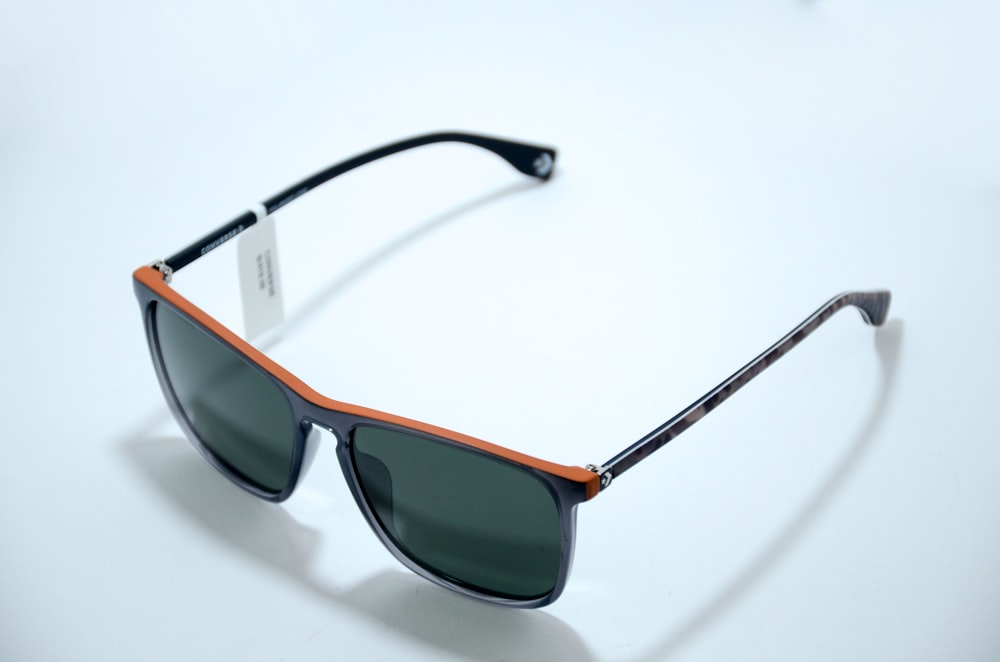 black framed sunglasses on white surface