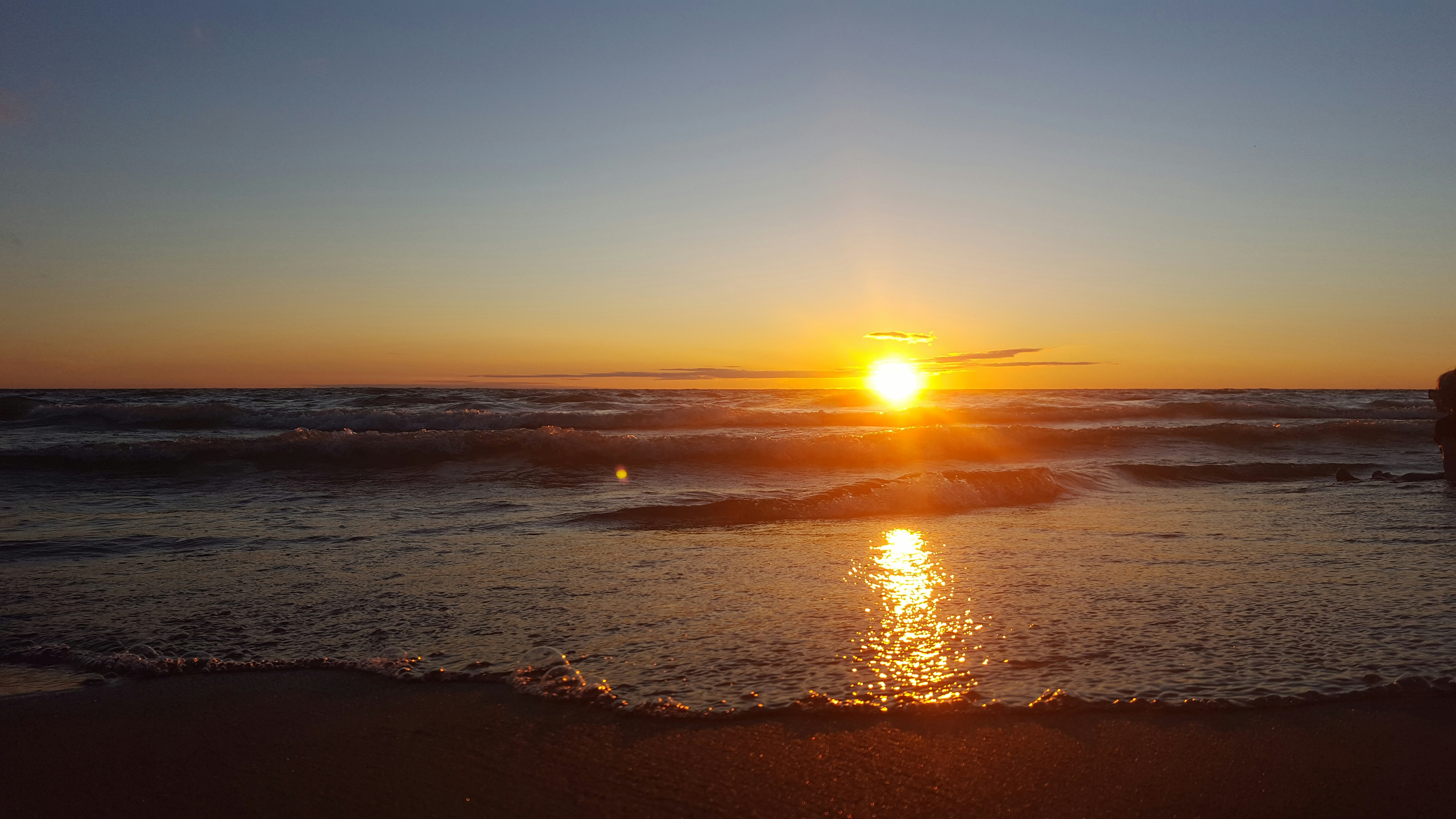 Sunset Over The Sea With Waves Crashing On Shore Photo Free Light Image On Unsplash