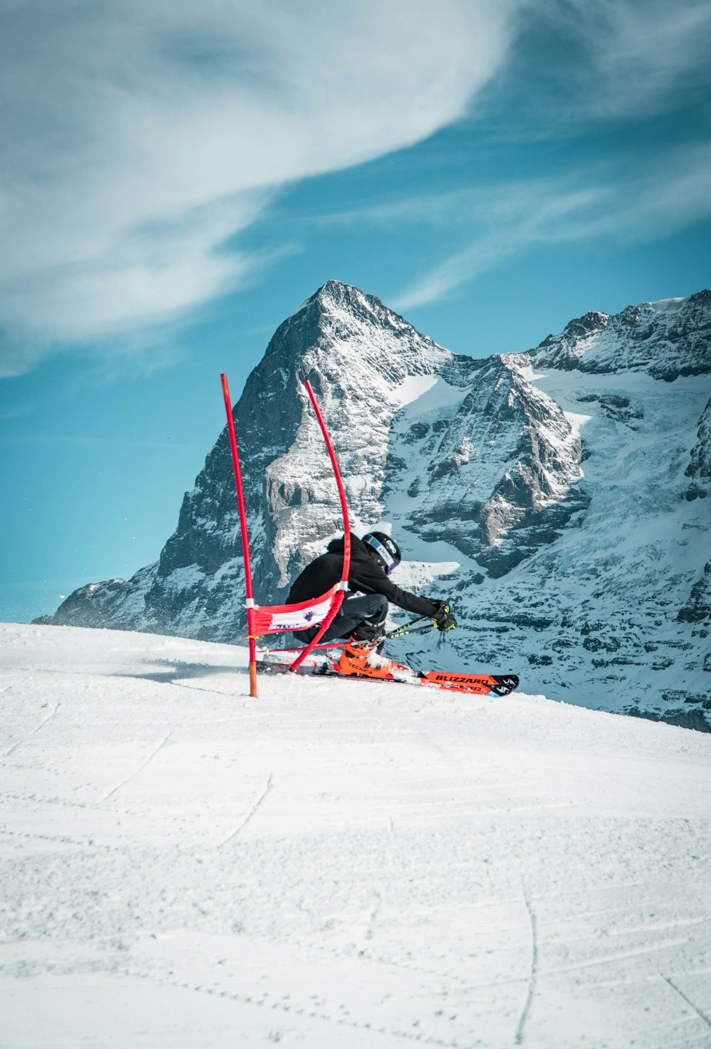 person in red jacket and black pants riding red ski board on snow covered mountain during