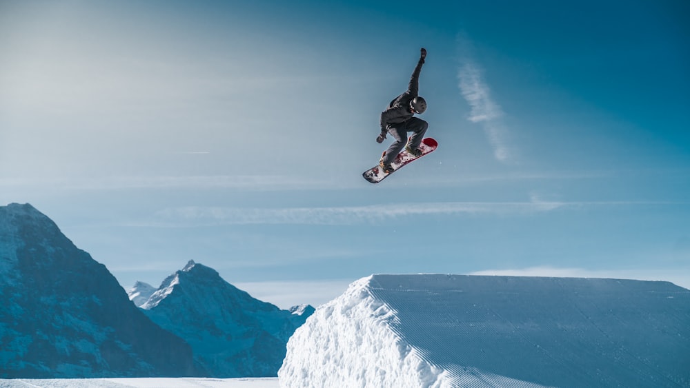 a man flying through the air while riding a snowboard