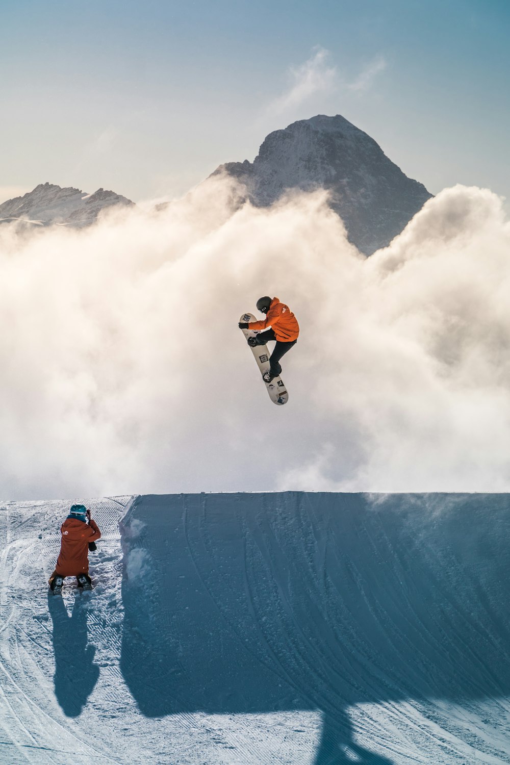 man in orange jacket and black pants doing snow ski during daytime