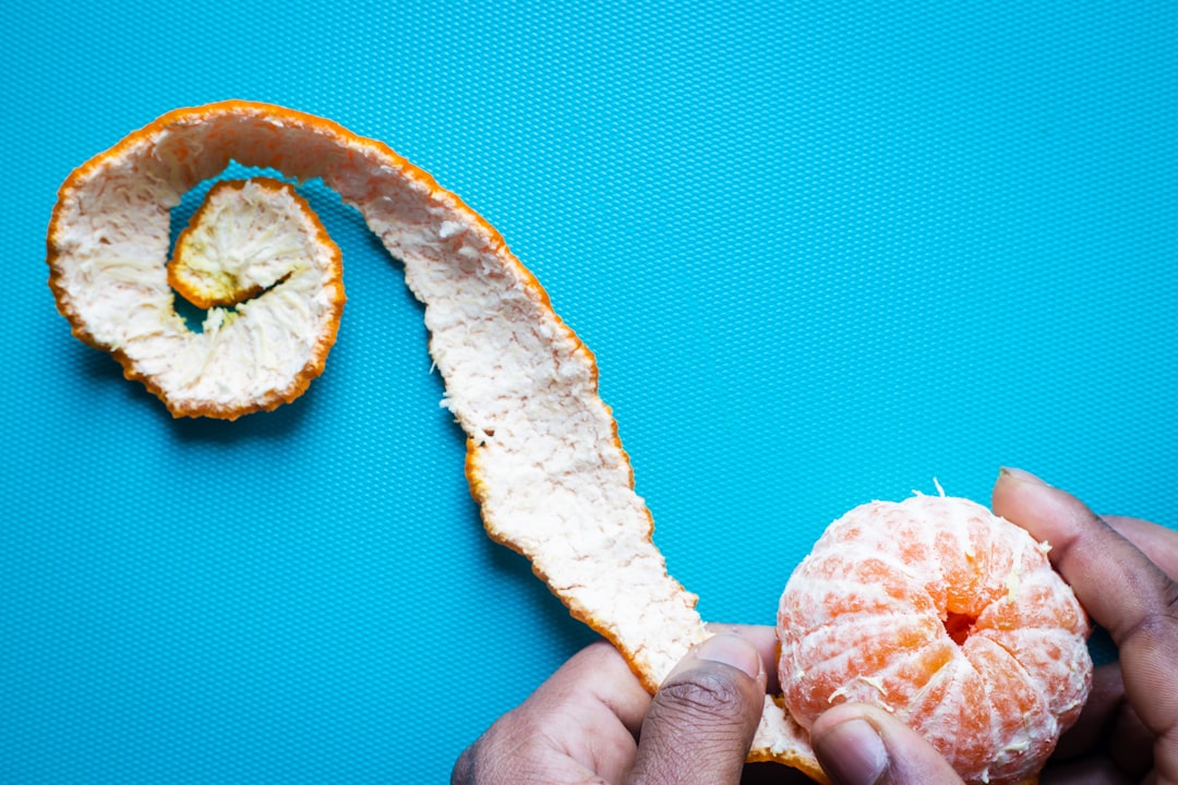 person holding sliced orange fruit