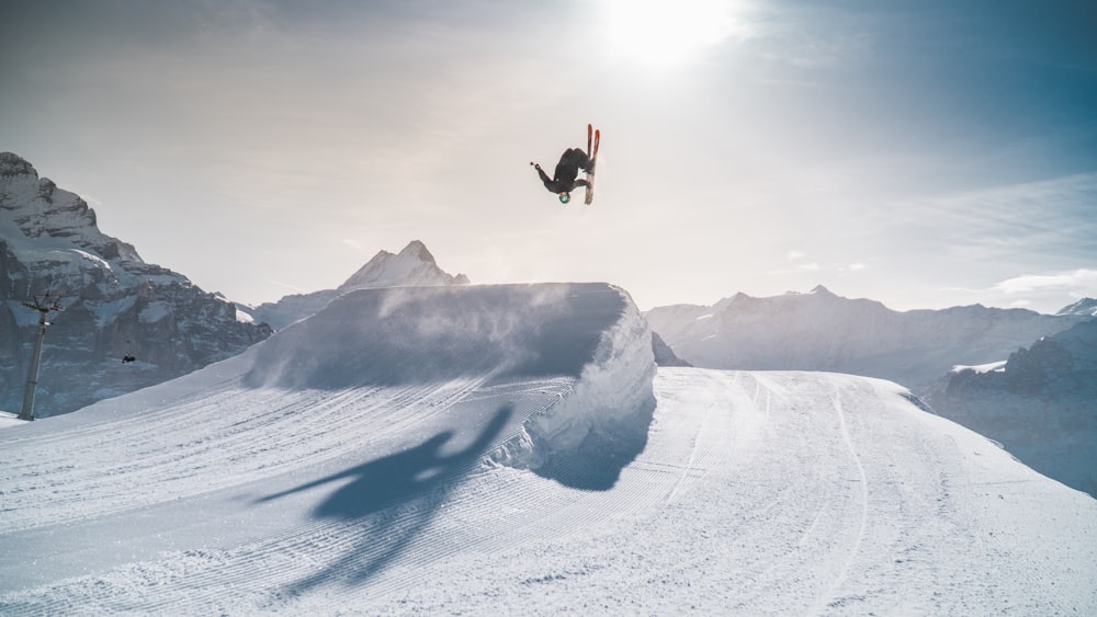 person in black jacket and black pants doing snow ski during daytime