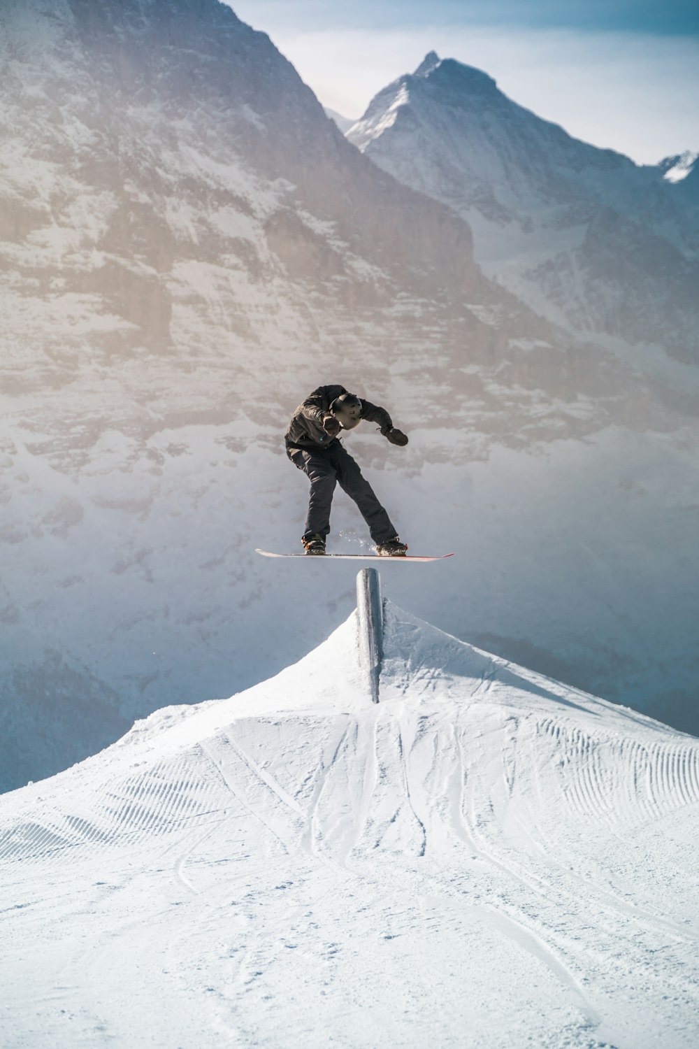 man in black jacket and black pants riding on snowboard during daytime