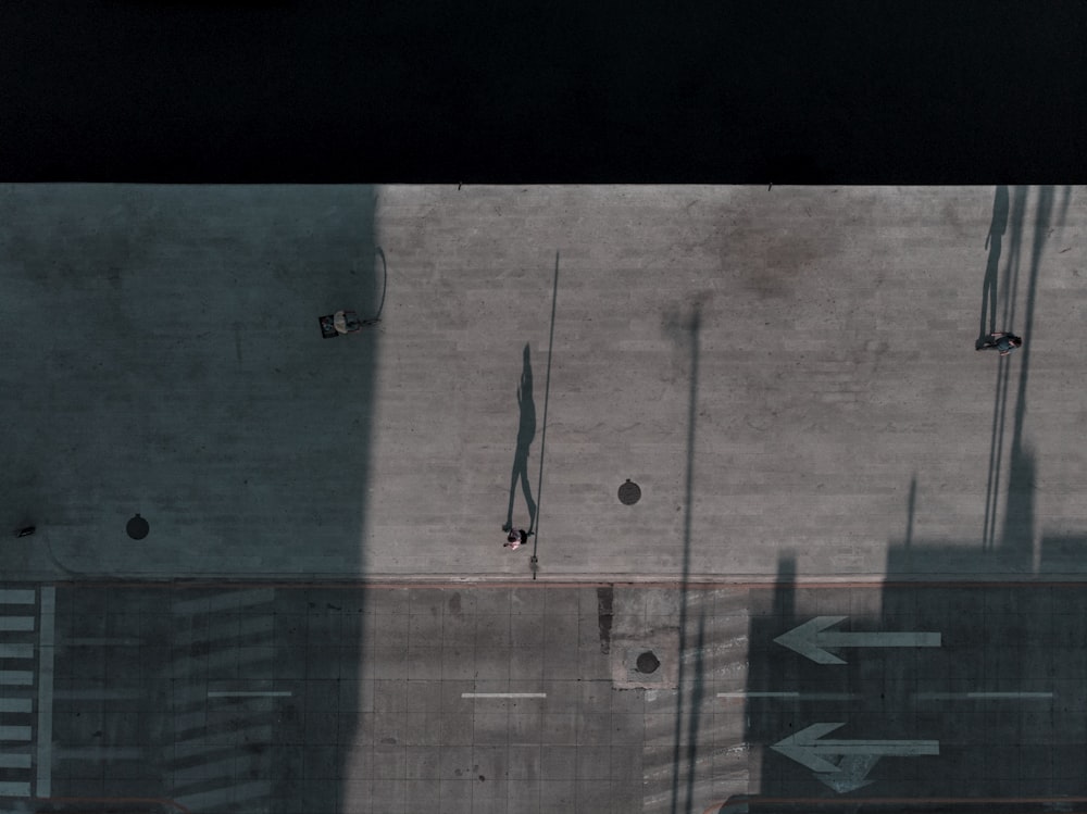 man in black shirt and pants standing on gray concrete wall