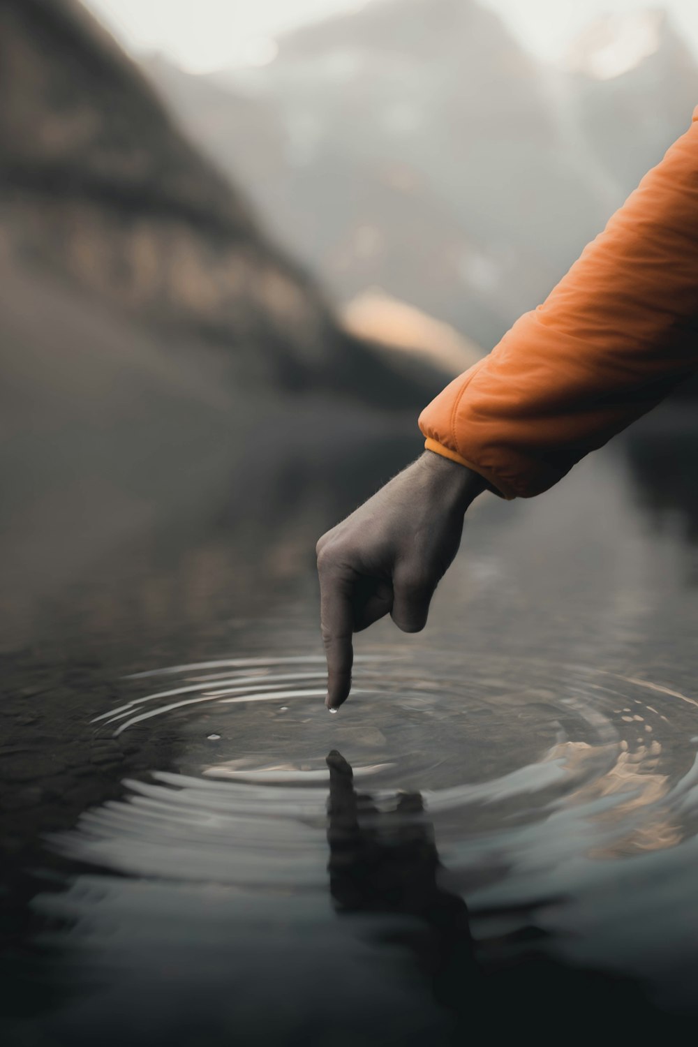 person in orange long sleeve shirt holding water