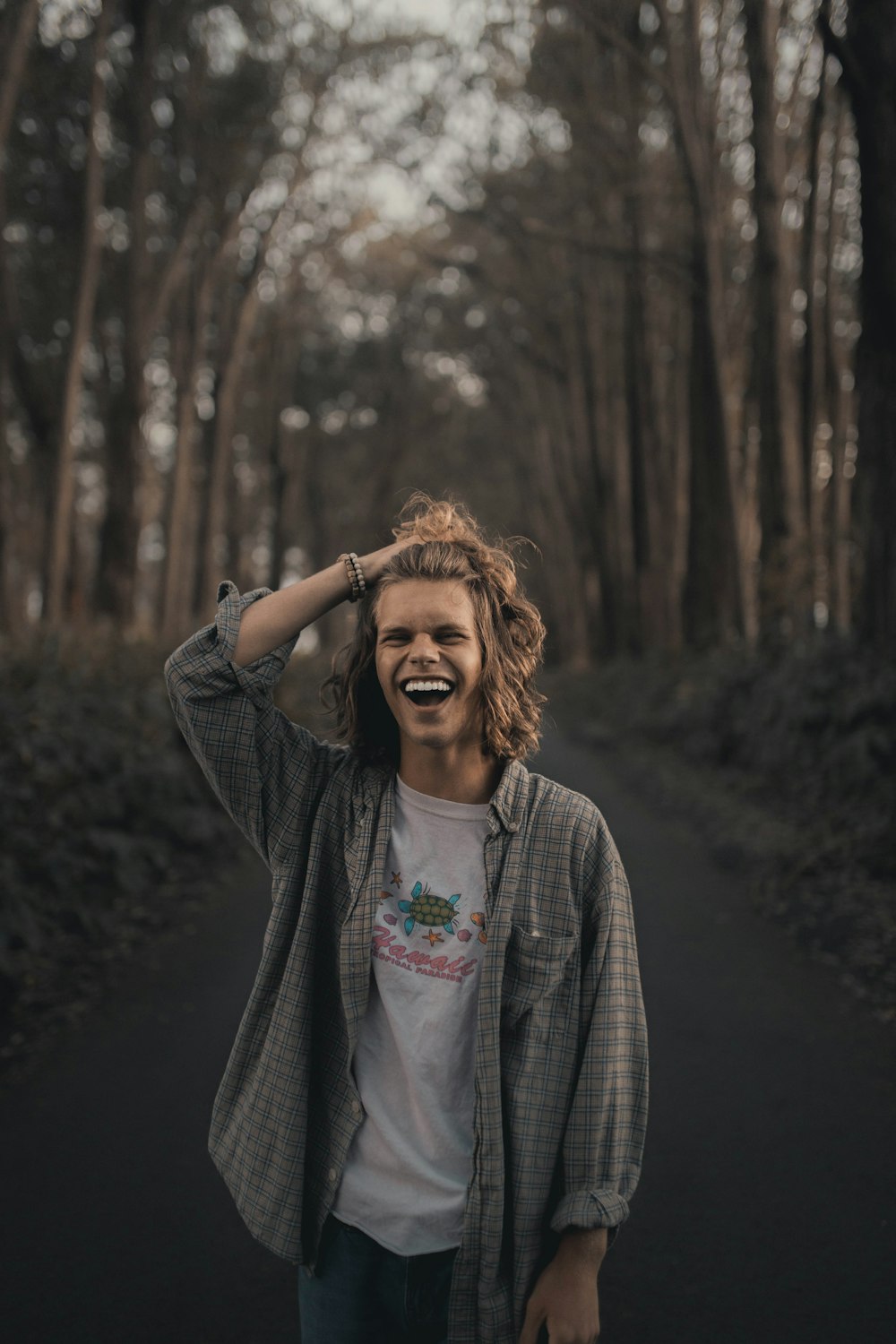 a person standing on a road with trees in the background