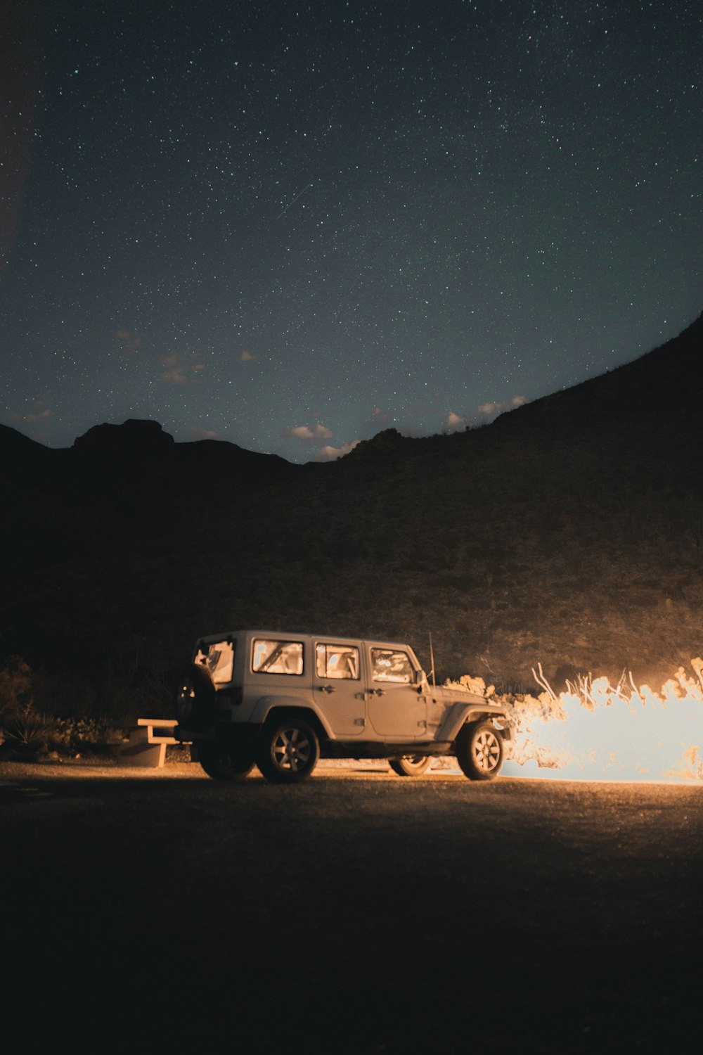 white suv on brown field during night time